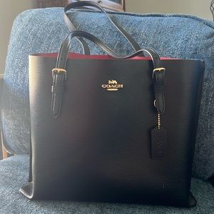 Coach bag. Black leather with red leather interior and gold hardware.